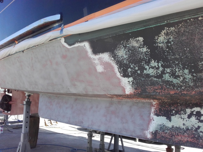 Décapage par sablage d’une peinture sur carène coque de bateau en acier à Cannes